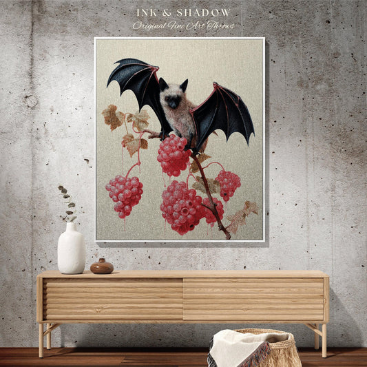 May include: A framed artwork featuring a bat with dark wings perched on a branch with red berries. The artwork has a neutral background and is labeled "INK & SHADOW Original Fine Art Throws". The artwork is displayed on a wooden cabinet.
