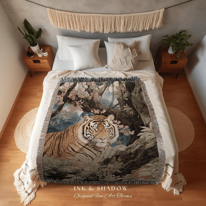 May include: A woven throw blanket featuring a detailed illustration of a tiger in a forest setting. The blanket has a fringed edge and the text "INK & SHADOW Original Fine Art Throws" at the bottom.