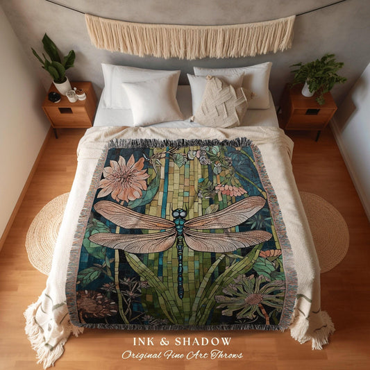 May include: A decorative throw blanket featuring a dragonfly design with a mosaic-like background. The dragonfly has tan wings and a blue body. The blanket is on a bed with white pillows and a cream-colored bedspread. The text "INK & SHADOW Original Fine Art Throws" is at the bottom.