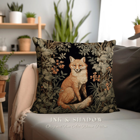 May include: A decorative throw pillow featuring a woven tapestry design of a red fox sitting in a forest setting. The fox is surrounded by green foliage and flowers. The pillow is black with a dark green and brown color scheme. The text "INK & SHADOW Original Fine Art Woven Pillow" is printed below the pillow.