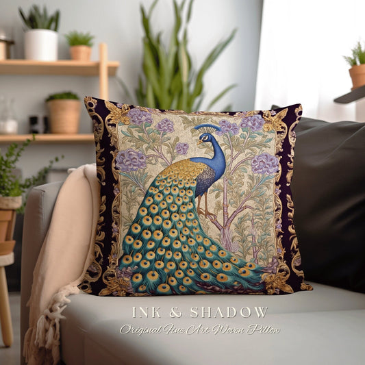 May include: A decorative pillow featuring a woven tapestry design of a peacock with a blue head and neck, a golden body, and a green and gold tail. The peacock is standing in a garden setting with purple flowers and gold accents. The pillow is labeled "INK & SHADOW Original Fine Art Woven Pillow".