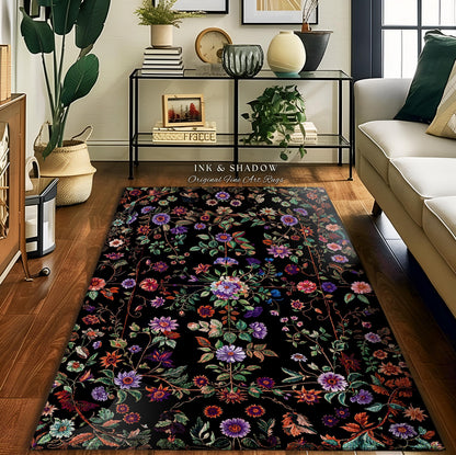May include: A rectangular black rug with a floral design in shades of purple, pink, and green. The rug features a border and the text "INK & SHADOW Original Fine Art Rugs". The rug is placed on a wooden floor.