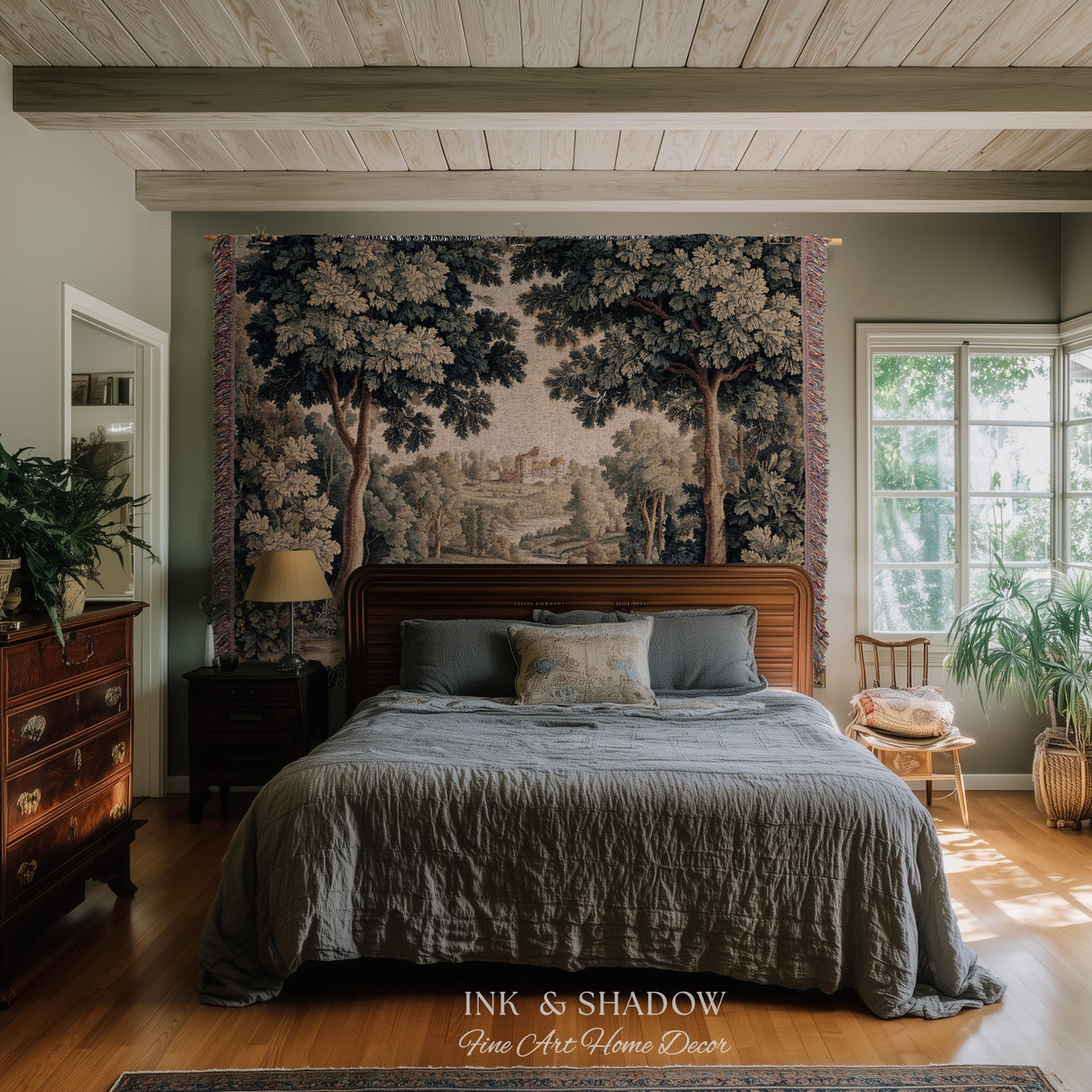 May include: A bedroom with a large tapestry depicting a forest scene above a wooden bed frame. The bed is covered with a gray comforter and pillows. The room has hardwood floors and a window with natural light. The text "INK & SHADOW Fine Art Home Decor" is at the bottom.