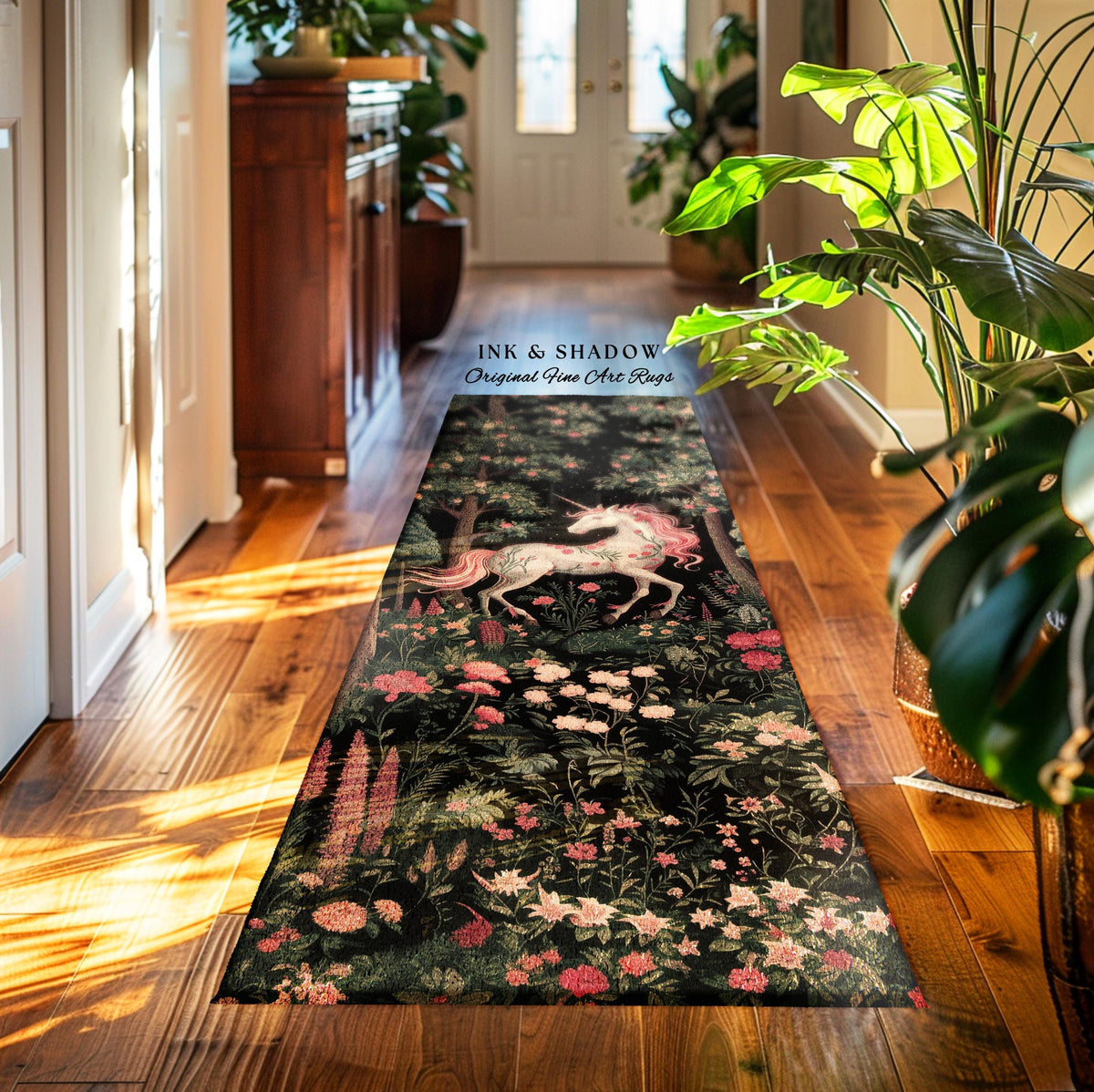 May include: A long rectangular runner rug featuring a dark black background with a repeating pattern of pink and white flowers, green foliage, and a central white unicorn with a pink mane. The text INK & SHADOW Original Fine Art Rugs is visible.
