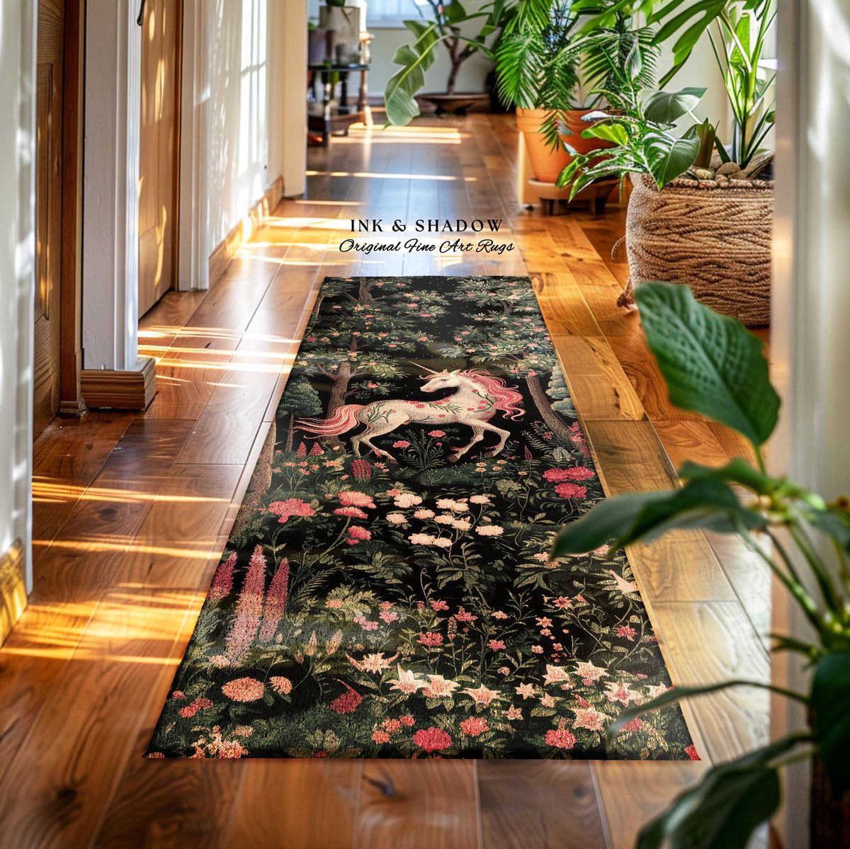 May include: A long rectangular runner rug featuring a dark black background with a central white unicorn, pink mane and tail, surrounded by detailed green foliage and various pink, white, and red flowers. The text INK & SHADOW Original Fine Art Rugs is visible.