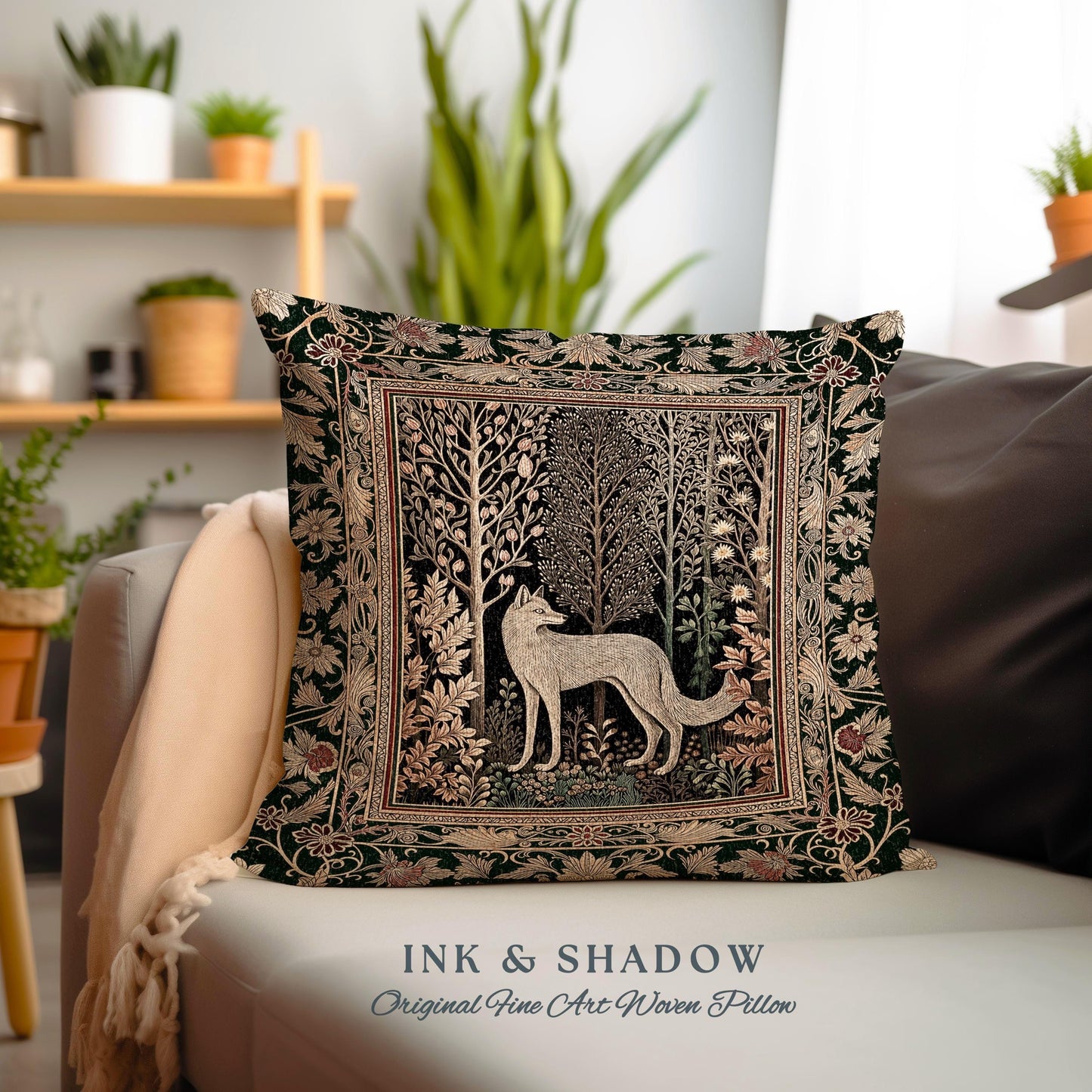 May include: A square throw pillow with a dark green background and a woven tapestry design. The design features a white fox standing in a forest with trees and flowers. The pillow has the text "INK & SHADOW Original Fine Art Woven Pillow" printed on the bottom.