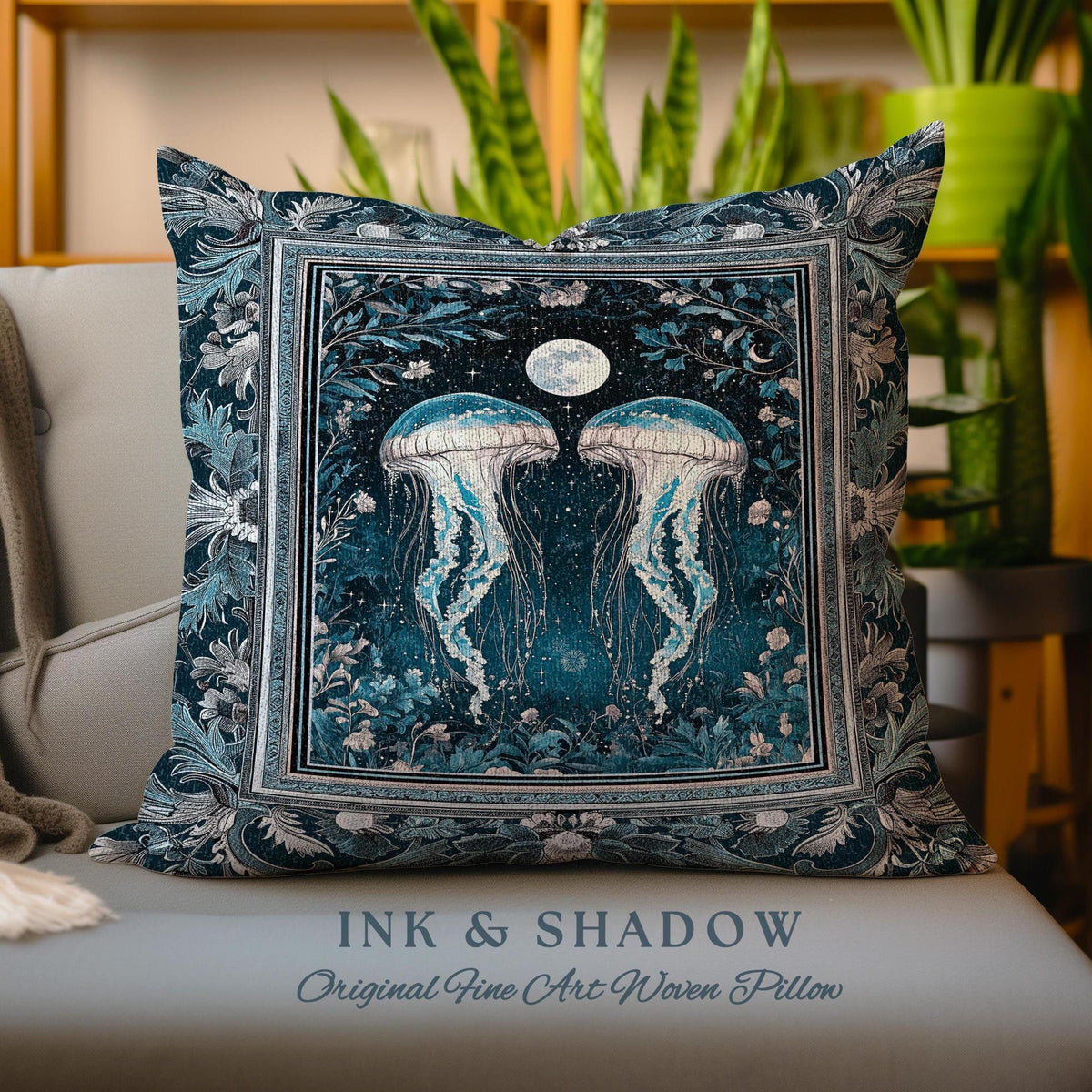 May include: A decorative pillow with a woven design featuring two jellyfish swimming in a dark blue ocean with a full moon and stars. The pillow has a silver frame and a border of floral designs. The text "INK & SHADOW Original Fine Art Woven Pillow" is printed below the pillow.