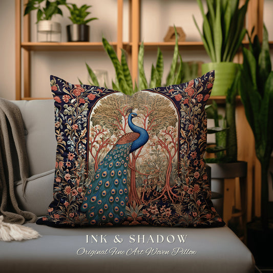 May include: A decorative pillow with a woven tapestry design featuring a peacock standing in a forest scene. The peacock has blue and green feathers. The pillow is navy blue with a red, orange, and green floral border. The text 'INK & SHADOW Original Fine Art Woven Pillow' is printed below the pillow.