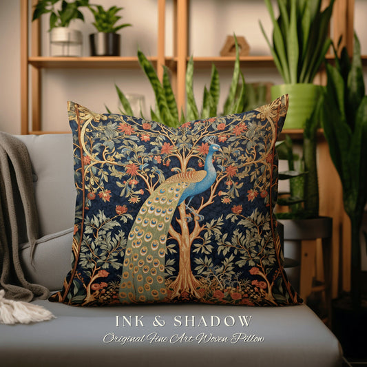 May include: A decorative throw pillow with a woven tapestry design featuring a peacock perched on a tree with intricate floral details. The pillow is navy blue with gold, green, and red accents. The text "INK & SHADOW Original Fine Art Woven Pillow" is printed on the bottom of the pillow.