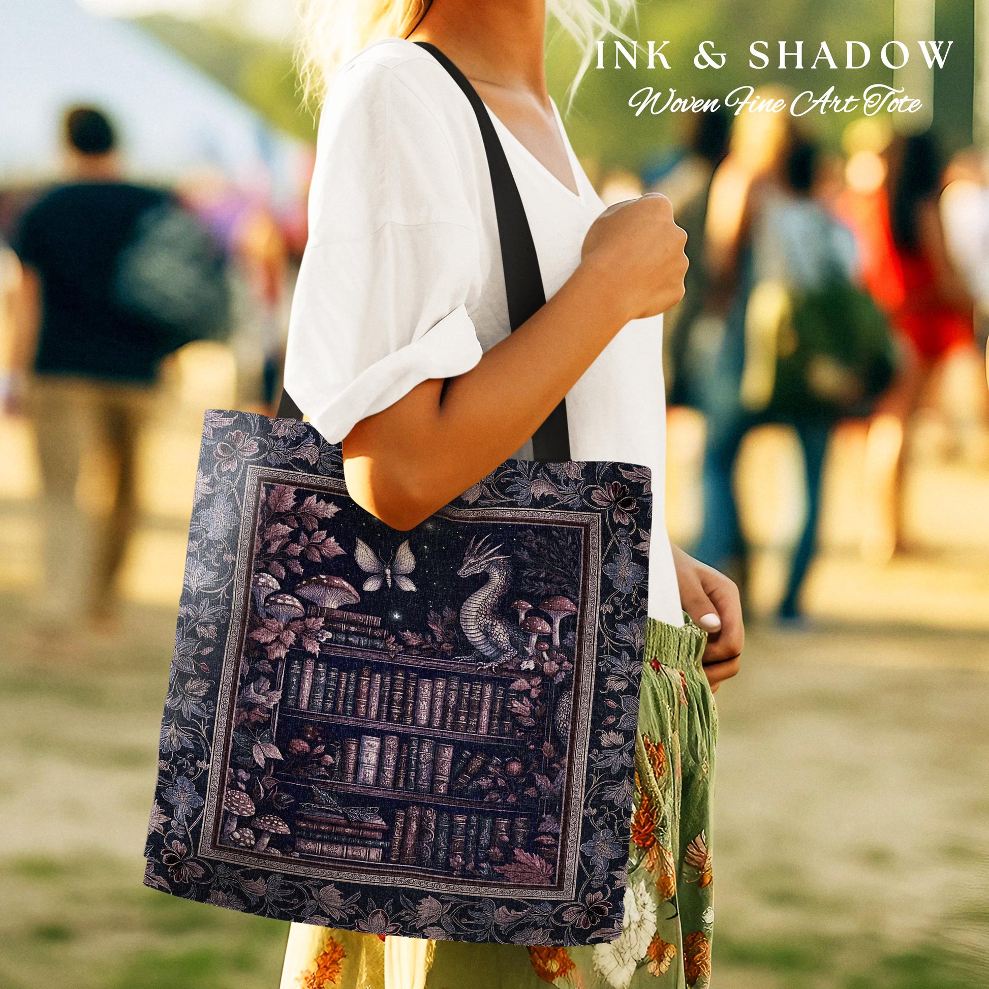 May include: A black tote bag with a woven design featuring a bookshelf, a dragon, mushrooms, and a butterfly. The text "INK & SHADOW Woven Fine Art Tote" is printed on the bag.