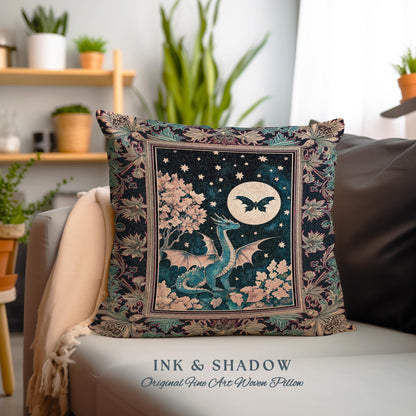 May include: A decorative pillow with a woven tapestry design featuring a blue dragon with wings spread, a full moon, and a black butterfly. The background is a dark blue with stars and a pink tree. The pillow has a black frame with a floral design.
