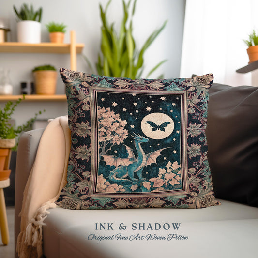 May include: A decorative pillow with a woven tapestry design featuring a blue dragon with wings spread, a full moon, and a black butterfly. The background is a dark blue with stars and a pink tree. The pillow has a black frame with a floral design.