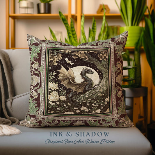 May include: Square decorative pillow with a detailed dragon illustration. The pillow features a dragon with outstretched wings, a full moon, and floral accents. The border has a floral pattern in shades of green and burgundy. The text "INK & SHADOW" is at the bottom.