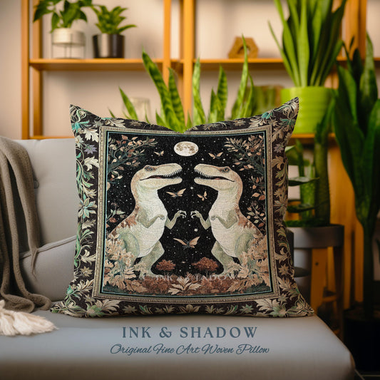 May include: A black and brown woven pillow with a tapestry design featuring two dinosaurs facing each other under a full moon. The dinosaurs are green and white with intricate details. The background is a dark forest scene with butterflies and stars. The pillow has the text "INK & SHADOW Original Fine Art Woven Pillow" at the bottom.