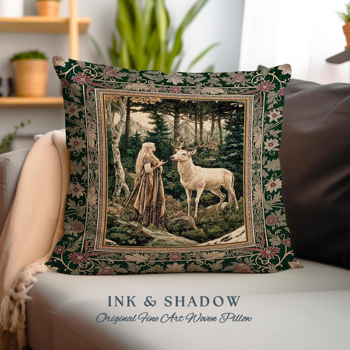 May include: A green throw pillow with a woven tapestry design featuring a woman in a forest with a white deer. The pillow has a gold frame and the text "INK & SHADOW Original Fine Art Woven Pillow" is printed on the bottom.