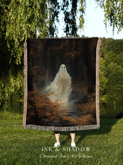May include: A woven throw blanket featuring a ghostly figure against a dark, textured background. The blanket has a fringed edge and the text "INK & SHADOW Original Fine Art Throws" at the bottom. The color palette includes black, brown, and white.
