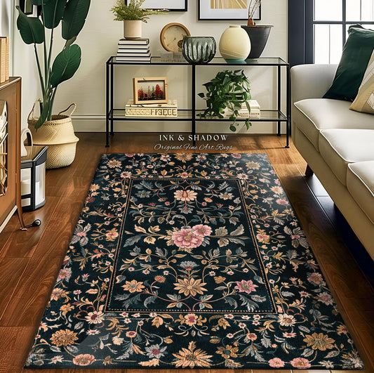 May include: A rectangular area rug with a dark background and a floral pattern. The rug features a central floral design in shades of pink, yellow, and blue, surrounded by a border. The text "INK & SHADOW Original Fine Art Rugs" is visible.