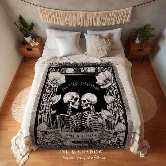 May include: Black and white throw blanket with a floral and skeleton design. The blanket features the text "OUR FIRST CHRISTMAS" and the names "JANET & KENNETH" with "EST 2022". The blanket is fringed and has the text "INK & SHADOW Original Fine Art Throws".