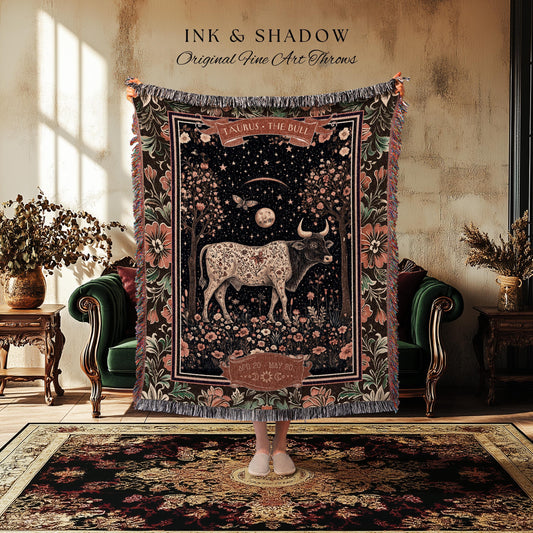 May include: A tapestry throw blanket featuring a Taurus the Bull design with a night sky background, flowers, and trees. The blanket has a fringed edge and the text "INK & SHADOW Original Fine Art Throws".