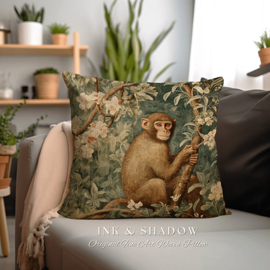 May include: A decorative throw pillow with a woven tapestry design featuring a monkey sitting in a tree with white flowers. The pillow has a green, brown, and white color scheme and the text "INK & SHADOW Original Fine Art Woven Pillow" is printed on the bottom.