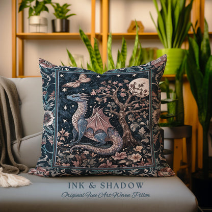 May include: A woven pillow featuring a blue dragon with pink wings in a forest setting with a full moon and stars. The pillow has a dark blue background with pink and green floral accents. The text "INK & SHADOW Original Fine Art Woven Pillow" is printed on the bottom of the pillow.