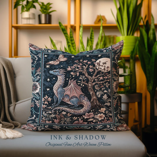 May include: A woven pillow featuring a blue dragon with pink wings in a forest setting with a full moon and stars. The pillow has a dark blue background with pink and green floral accents. The text "INK & SHADOW Original Fine Art Woven Pillow" is printed on the bottom of the pillow.