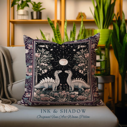 May include: A purple and pink woven pillow with a design of two dinosaurs standing under a full moon in a forest. The pillow has the text "INK & SHADOW Original Fine Art Woven Pillow" at the bottom.