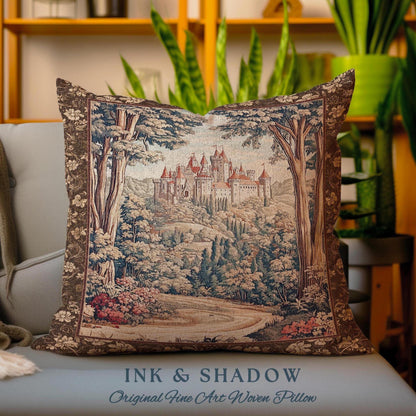 May include: A tapestry pillow featuring a detailed illustration of a castle nestled in a lush forest. The pillow has a brown border and the text "INK & SHADOW Original Fine Art Woven Pillow" is printed on the bottom.