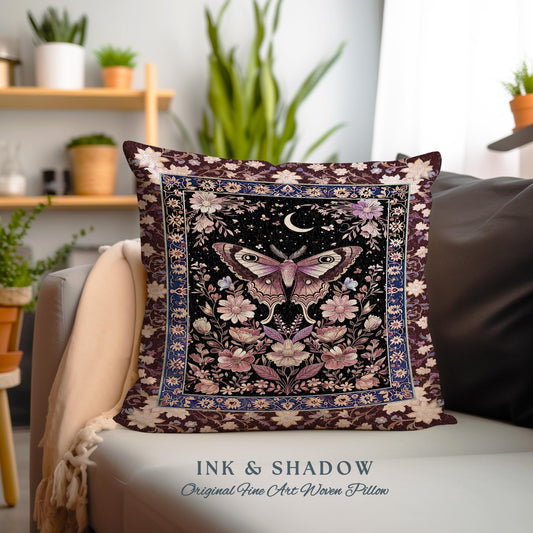 May include: A decorative pillow with a woven tapestry design featuring a moth with large eyes, surrounded by flowers and a crescent moon. The background is a dark blue with a burgundy border. The text "INK & SHADOW Original Fine Art Woven Pillow" is printed below the pillow.