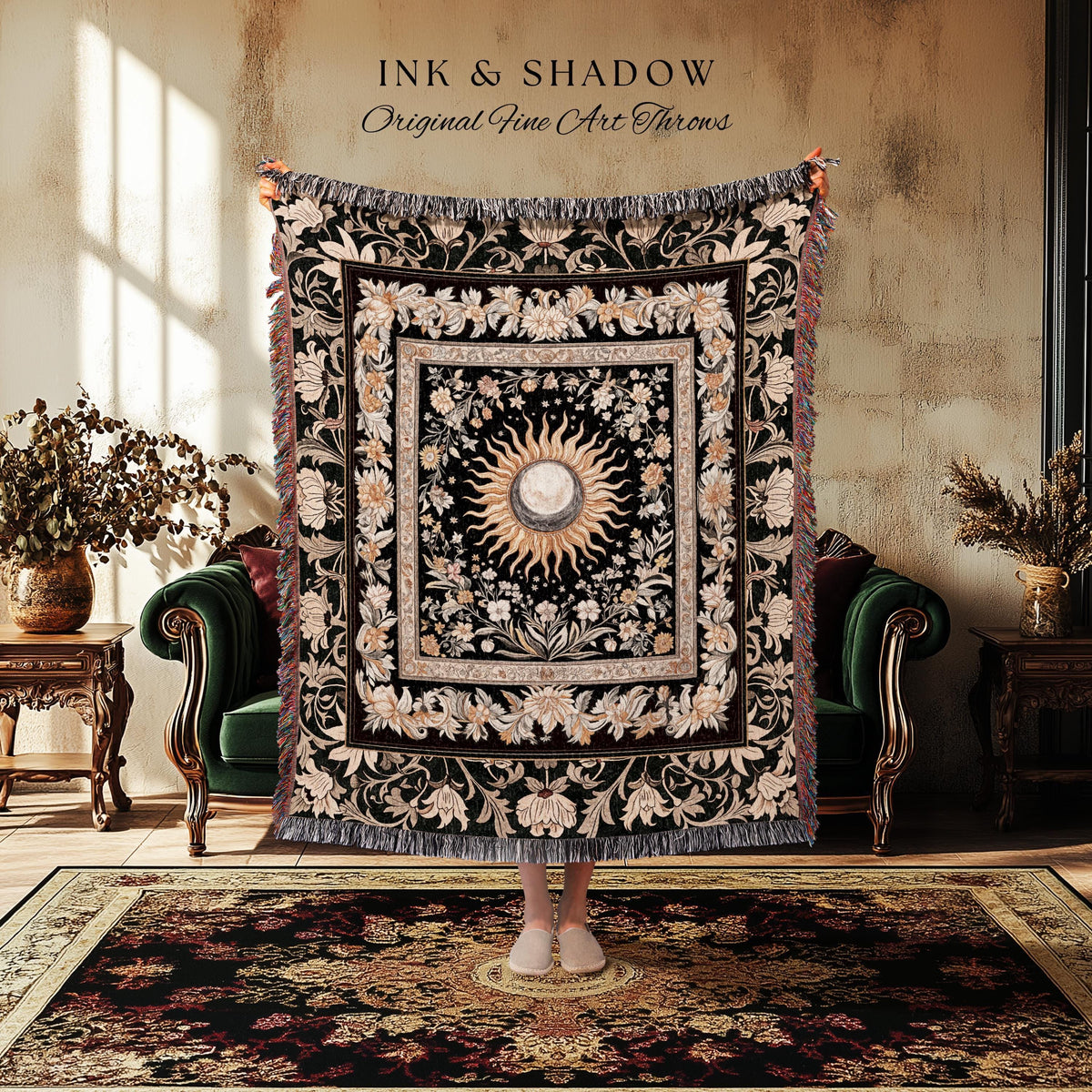 May include: A black throw blanket with a floral and sunburst design. The blanket has a square center with a sun and moon design, surrounded by floral patterns. The text "INK & SHADOW Original Fine Art Throws" is at the top.