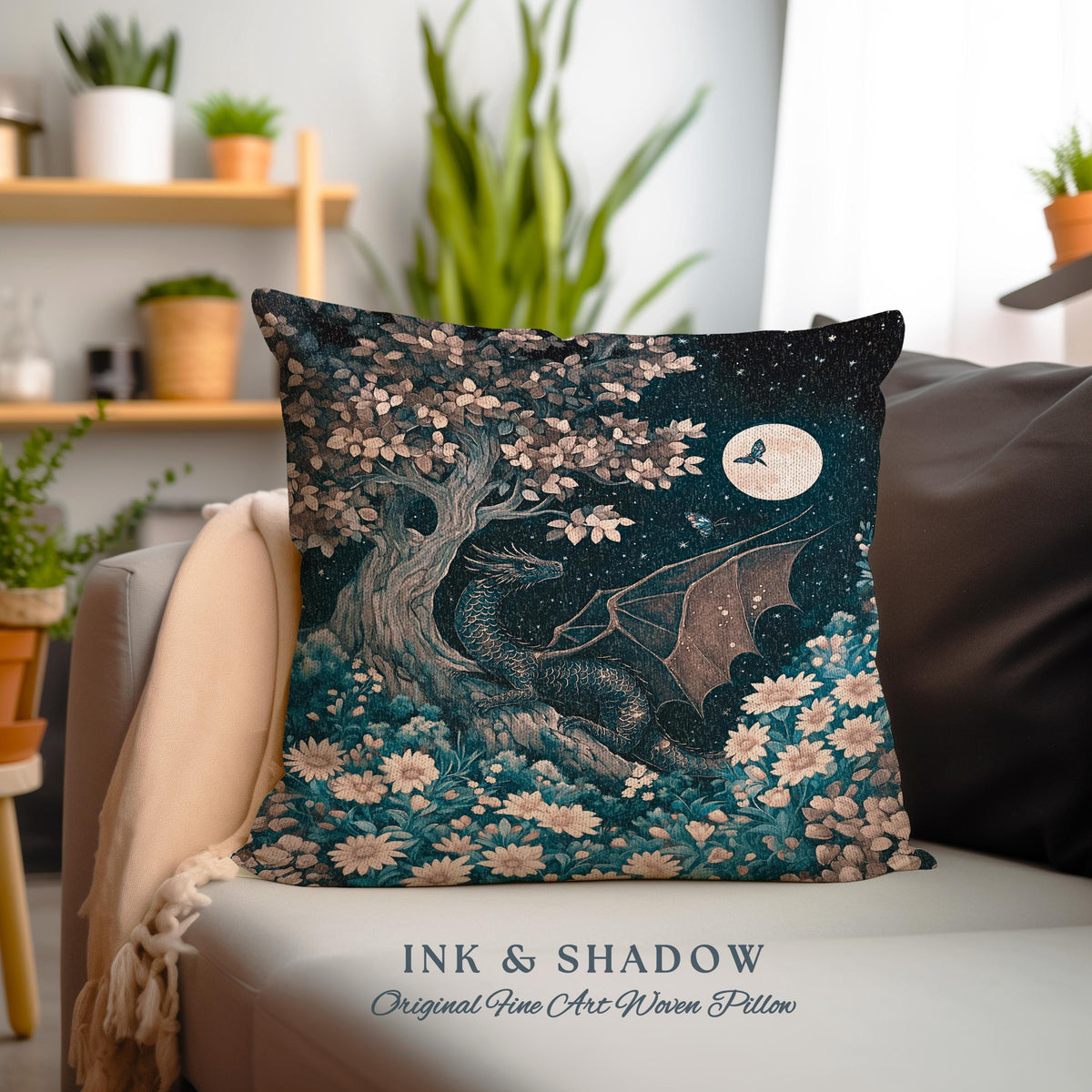 May include: A decorative pillow featuring a woven design of a dragon in a forest setting with a full moon and a butterfly. The pillow has a teal, blue, and brown color scheme and the text "INK & SHADOW Original Fine Art Woven Pillow".