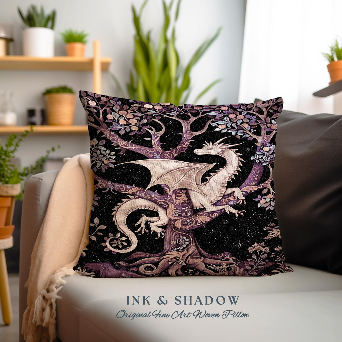 May include: A decorative pillow featuring a white dragon perched on a tree with purple and gold branches against a black background. The pillow has the text "INK & SHADOW Original Fine Art Woven Pillow" at the bottom.