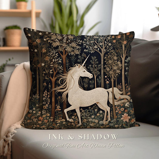 May include: A white unicorn with a gold horn stands in a dark forest with green and brown trees and flowers. The background is a dark blue color. The pillow is made of woven fabric and has the text "INK & SHADOW Original Fine Art Woven Pillow" printed on the bottom.