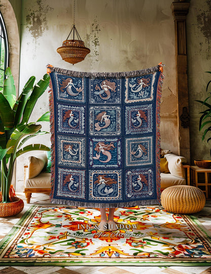 May include: A navy blue throw blanket featuring a repeating pattern of mermaids in square frames. The blanket has a fringed edge with orange and brown accents. The text "INK & SHADOW Original Fine Art Throws" is visible at the bottom.