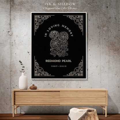 May include: A framed black art print with the text "IN LOVING MEMORY" and "REDMOND PEARL 1987-2023". The print features a floral illustration and decorative corner designs. The words "Ink & Shadow Original Fine Art Throws" are at the top.